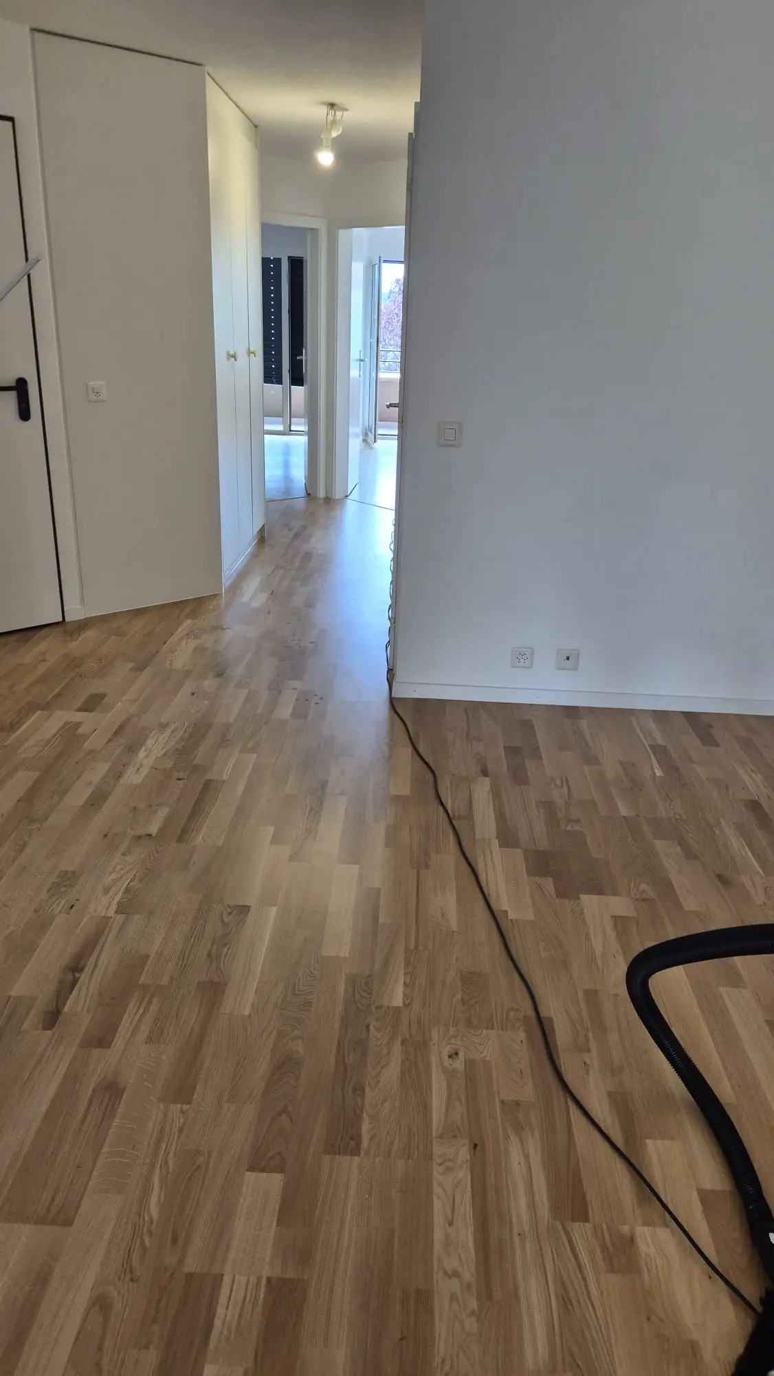 Pose du parquet en cours dans une pièce à Gland
