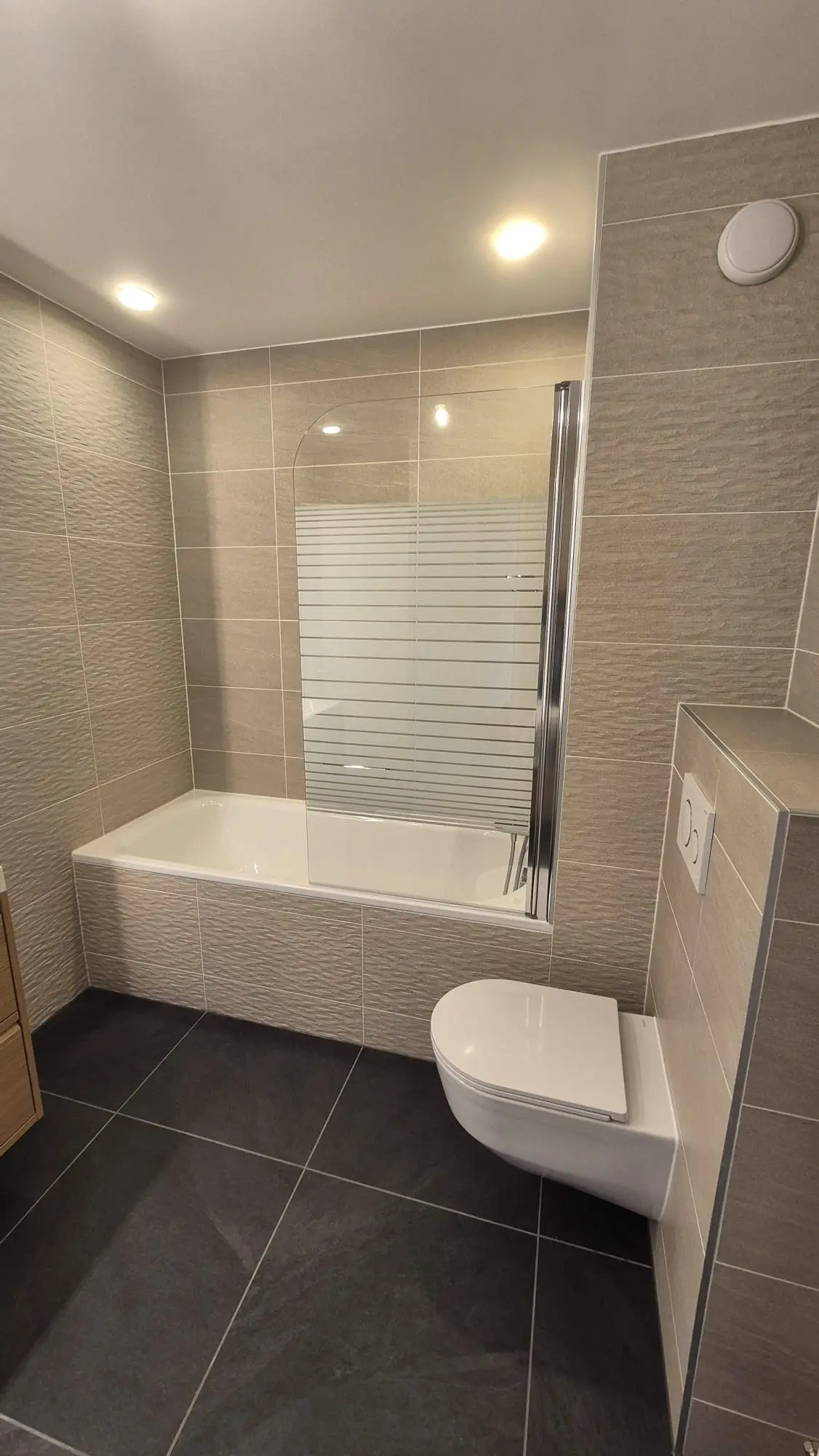 Meuble suspendu et robinetterie posés dans une salle de bain à Nyon